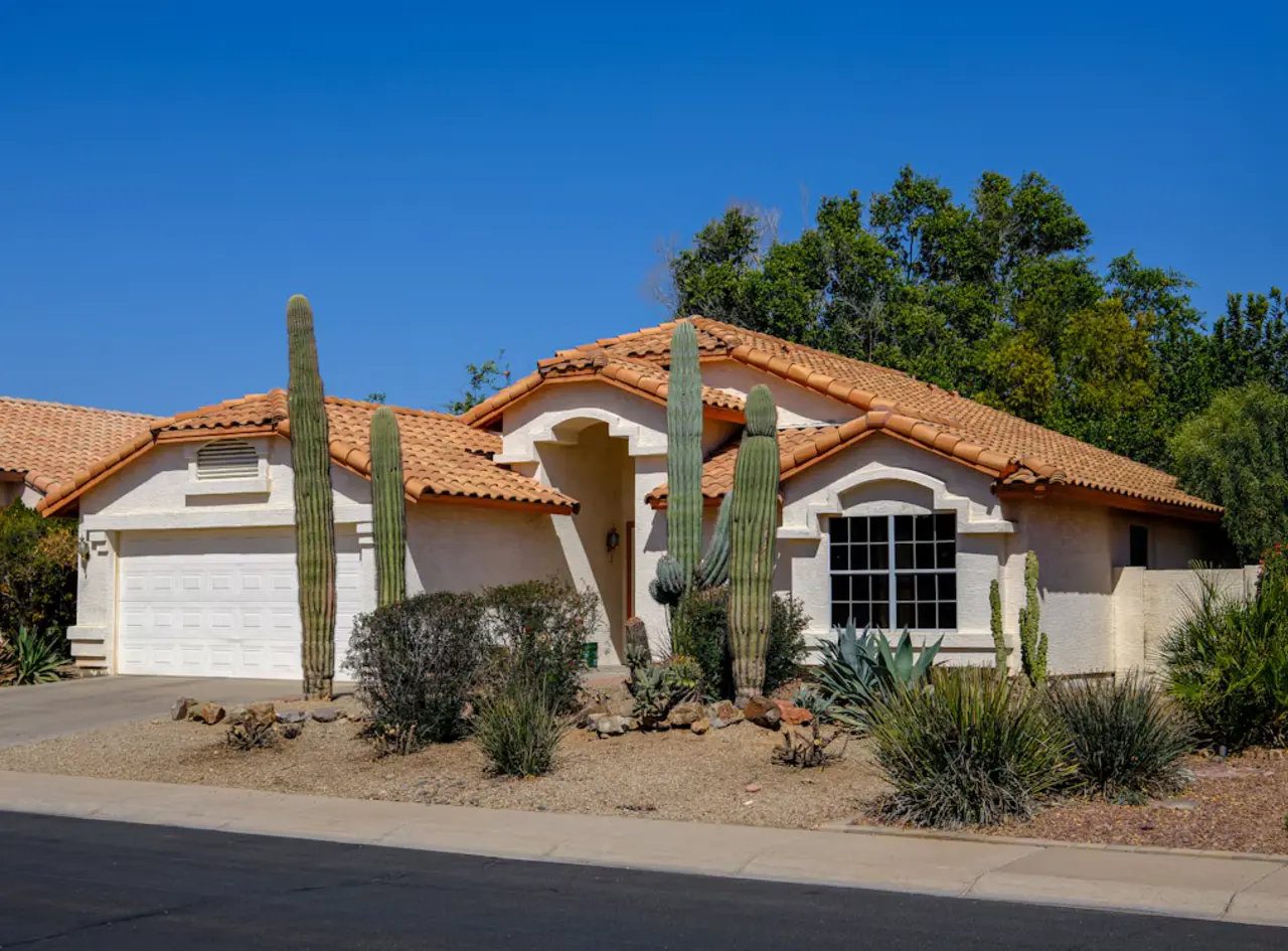 Arizona stucco home with desert landscaping and saguaro cacti